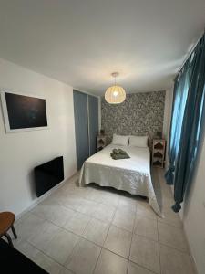 a bedroom with a white bed and a tv at Grand appartement spacieux 3 ch Rez de villa a sisco in Sisco