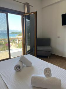 una camera da letto con asciugamani su un letto e vista sull'oceano di Hotel Lula Ksamil a Ksamil Altre 37 foto