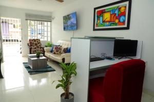 a living room with a desk with a computer on it at HABITACION SMART - baño semiprivado in Cali