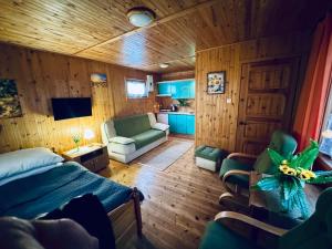 a bedroom with a bed and a living room at Domek nr 7 in Tleń