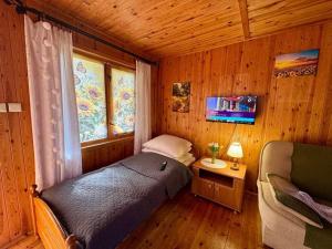 a bedroom with a bed in a wooden room at Domek nr 7 in Tleń