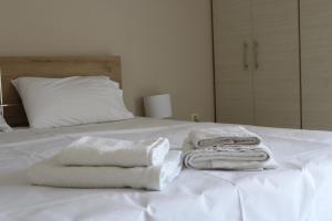 a white bed with towels on top of it at Dream House 3 in Xanthi
