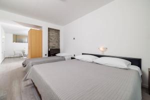 two beds in a room with white walls at Apartments Jadranka in Dramalj