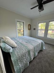 a bedroom with a bed and two windows at Beachside Walk & Casino Retreat - Breakfast - Hot Tub - Game Room in Gulfport