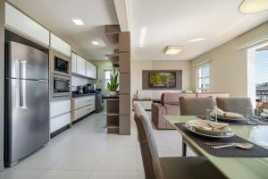 a kitchen and living room with a stainless steel refrigerator at Achei Itapema • Beira-mar e piscina em Porto Belo in Porto Belo