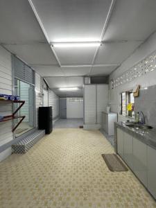 a large room with a kitchen with a tile floor at FAKIH Homestay in Tumpat