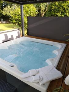 a hot tub sitting on top of a deck at Gîte La Jacarandière in Plumieux