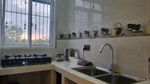 a kitchen counter with a sink and a window at Nahita Apartment in Kibigija