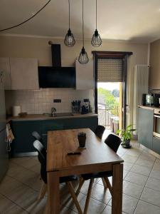 cocina con mesa de madera y sillas en Casa di Luisa, en Savigliano