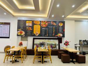 a restaurant with tables and a menu on the wall at Peaceful Mountain Hotel in Ha Giang