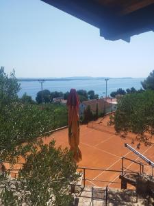 a tennis court with an umbrella on the court at Villa Milas - Apartman 04 in Tkon +3 photos