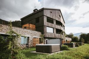 a building with a bath tub in front of it at Brondstott Farm & Suites Kronplatz in Riscone