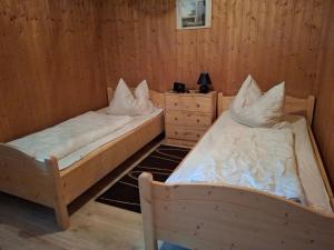 due letti in una stanza con pareti in legno di Ferienhaus Tamara In Eppenschlag a Eppenschlag