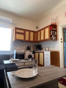 eine Küche mit einem Holztisch mit einem Teller darauf in der Unterkunft Ciel apartment in Rhodos (Stadt)