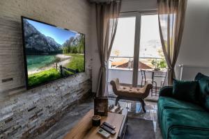 a living room with a flat screen tv on a brick wall at Apartman Despot LUX in Banja Koviljača