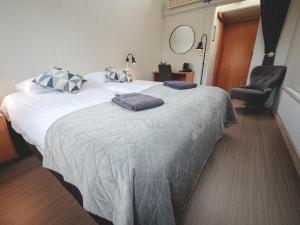 a bedroom with a bed with two towels on it at Hótel Skálholt in Golden Circle in Skálholt