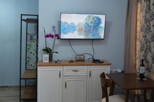 a room with a white cabinet with a painting on the wall at Colorsphere in Thessaloniki