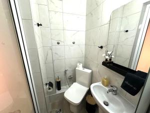 a white bathroom with a toilet and a sink at Colorsphere in Thessaloniki