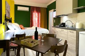 a kitchen with a table and a room with a bed at Colorsphere in Thessaloniki