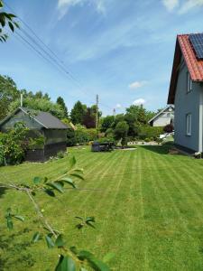 a yard with a large lawn with a house at Zakątek u Grzesia Gril & Chill in Trzebieszewo