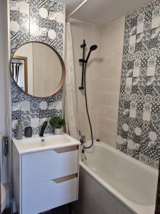Un baño con lavabo, espejo y bañera. en Dream Studio Petrosani, en Petroşani 18 fotos más