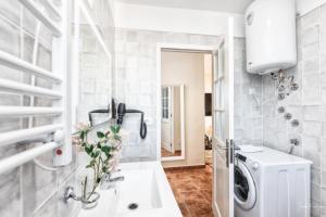 a white bathroom with a washing machine in it at Casa Conrado, 2 bedroom modern oasis, good location in Puntallana