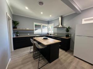 a kitchen with black cabinets and a white refrigerator at Big home perfect for the whole group in Morwell
