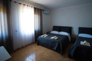 a bedroom with two beds and a window at Ela's apartment 1 in Durrës +1 photo