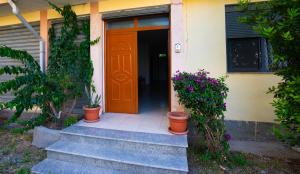an orange door on a house with potted plants at Ela's apartment 1 in Durrës