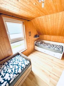Un dormitorio con dos camas en una cabaña de madera. en Domek Gaja, en Władysławowo