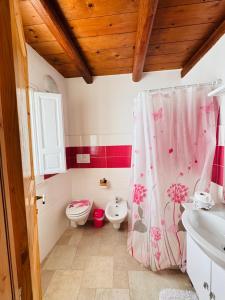 a bathroom with a pink shower curtain and a toilet at Casa Vacanze Moonlight in Polignano a Mare +6 photos
