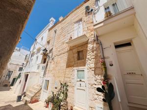 an alley with a white door and a building at Casa Vacanze Moonlight in Polignano a Mare