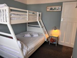 ein Schlafzimmer mit zwei Etagenbetten in einem Zimmer in der Unterkunft Sandpiper Seaside Maisonette in Hartley