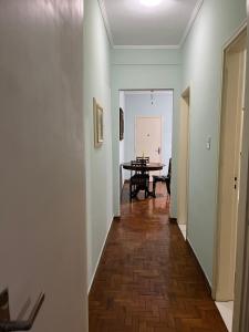 un couloir avec une table et une salle à manger dans l'établissement Apartamento confortável no centro, à Águas de Lindóia