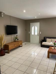 a living room with a couch and a flat screen tv at Maison de vacances in Le Thor