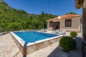 a swimming pool in front of a house at Wild silence - Skadar Lake in Virpazar