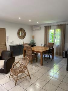 a living room with a wooden table and chairs at Maison de vacances in Le Thor
