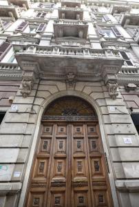 un edificio alto con una porta di legno di Minerva mini a Bari