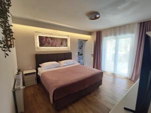 ein Schlafzimmer mit einem Bett und einem großen Fenster in der Unterkunft Apartment FortyTwo in Orebić