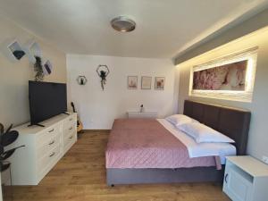 ein Schlafzimmer mit Bett und Flachbildfernseher in der Unterkunft Apartment FortyTwo in Orebić
