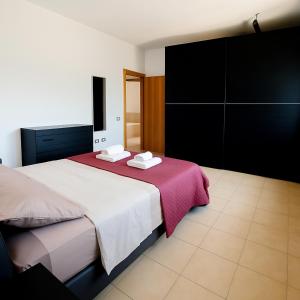 a bedroom with a large bed with a red blanket at Country house in Iglesias