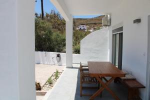a wooden table and chairs on the balcony of a house at Lefkes Beach Suite in Kithnos