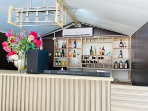 a bar with a vase of flowers on a counter at Henry George Hotel in Pretoria