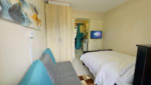 a small bedroom with a bed and a television at Studio apartment Westlands Kitisuru in Nairobi