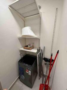 a kitchen with a shelf and a white hood at Luxury & Comfy studio in the heart of Melaka in Melaka
