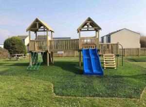 a playground with two play equipment in a yard at 39 Perran View Your Home Away from Home in Cornwall in St. Agnes