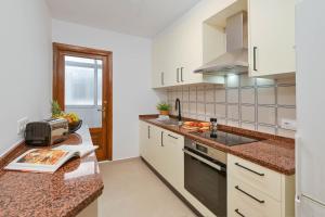 a kitchen with white cabinets and a counter top at Carmencita in Moraira