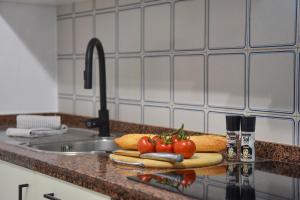 a kitchen counter with tomatoes on a cutting board next to a sink at Carmencita in Moraira +11 photos