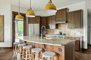 a kitchen with a large island with bar stools at Lake Travis Luxe Villa - 4BR, Pickleball & BBQ in Edgewater Beach