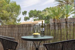a table with a bottle of wine and a bowl of fruit at Carmencita in Moraira